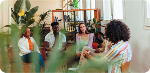 A group of diverse people sitting in a room talking.