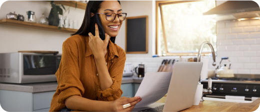 A woman speaking on the phone and looking at a file.